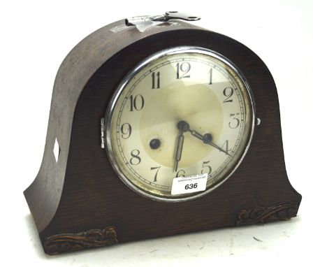 A 20th century mantle clock, the silvered dial with Arabic numerals, within a domed mahogany case with carved details, raised