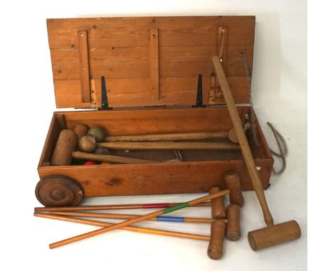 A vintage wooden croquet set, including adult and child's set, in original wooden box, of which having two wheels to one end
