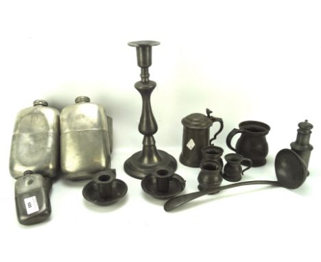 A collection of pewter wares, to include two oversized flasks, sauce ladle, two chamber sticks and more