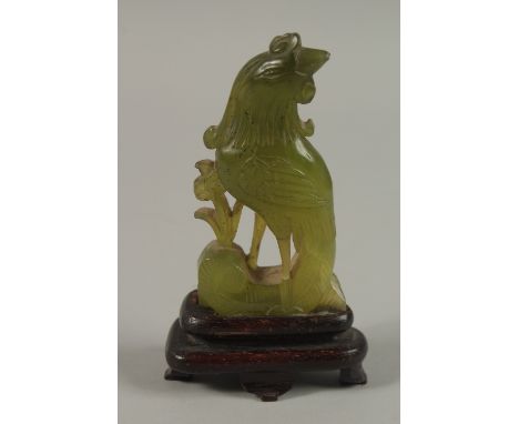 A SMALL CHINESE CARVED JADE COCKEREL AND WOODEN STAND, jade 8.5cm high.