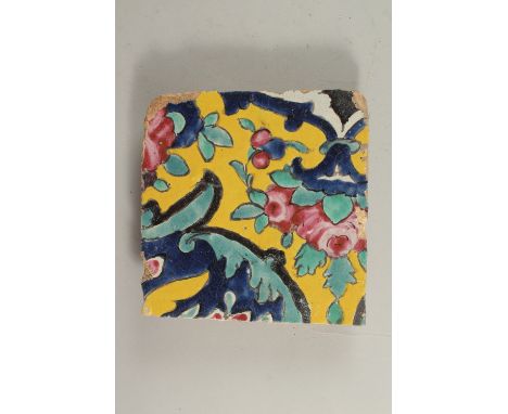 AN EARLY 19TH CENTURY PERSIAN YELLOW GLAZED POTTERY TILE, 18cm x 18cm.