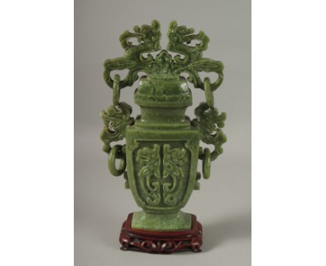 A LARGE CHINESE CARVED JADE LIDDED VASE, with twin drop ring handles and carved with dog of o, mounted to a wooden stand, 41c