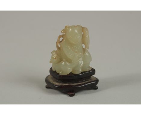 A CHINESE MINIATURE JADE CARVING OF AN IMMORTAL WITH ANIMAL, on a wooden stand, jade 3.5cm high.