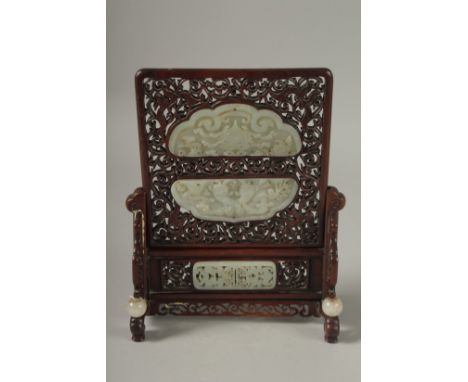 A PAIR OF SHAPED JADE PLAQUES INSET WITHIN A HARDWOOD FRAME, creating a carved wood table screen, height 27cm high, 20cm wide