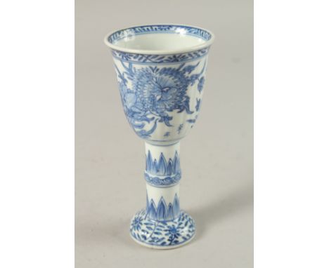 A CHINESE KANGXI PERIOD BLUE AND WHITE PORCELAIN STEM CUP, finely painted with native flora, 15.5cm high.
