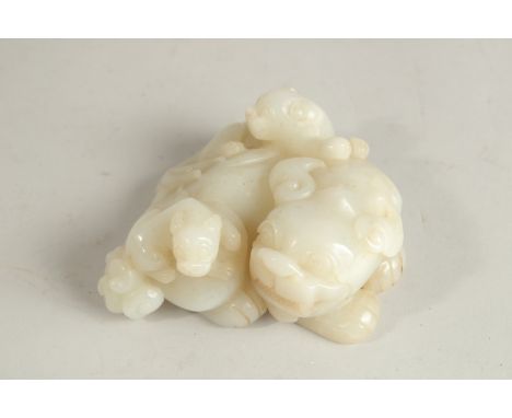 A CHINESE WHITE JADE CARVING OF A MYTHICAL LION, with incised characters to base, 11cm wide, 5cm high.