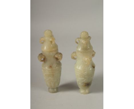 A PAIR OF 18TH CENTURY CARVED JADE VASES AND COVERS, with ram mask handles and carved scrolls, 19cm high.