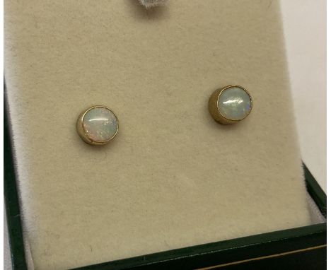 A pair of 9ct gold opal set stud earrings. Each earring approx. 5mm diameter. 