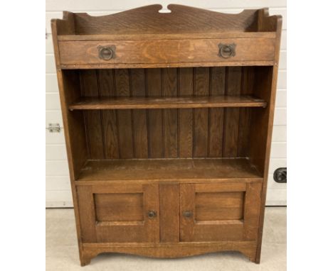 A vintage dark oak heavy bookcase with Arts &amp; Crafts design metal hooped handles. 2 door cupboard base with central solid