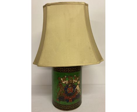 A toleware style green painted lamp base with Greek key and coat of arms detail. Complete with a large yellow lamp shade. Tot