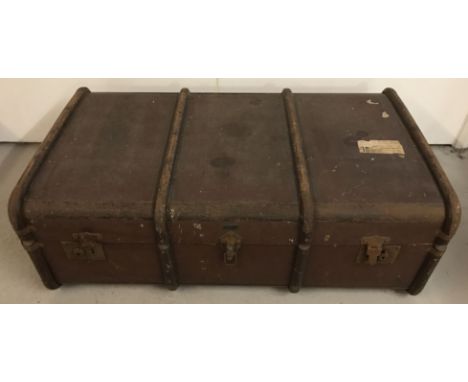 A vintage wooden and metal banded travelling trunk by Drawco, with leather carry handles. Paper lined interior with removeabl