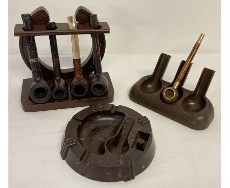 A collection of assorted vintage pipes and pipe rests to include wooden and Bakelite examples.  