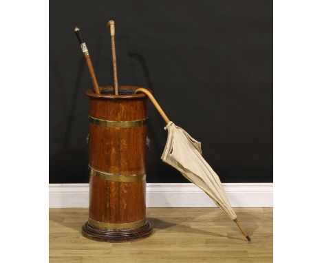 An early 20th century brass bound coopered oak cylindrical walking stick or umbrella stand, lion mask handles, turned base, 6