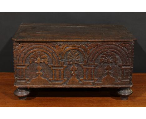 An 18th century Italian oak boarded table box, hinged top, the front panel carved with a row of architectural arches centred 