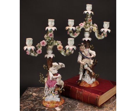 A pair of 19th century German porcelain figural four-light, three-branch candelabra, as a shepherd and shepherdess, they both