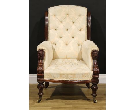A Victorian mahogany library chair, stuffed-over deep-button upholstery, the hand rests carved as lion masks, turned forelegs