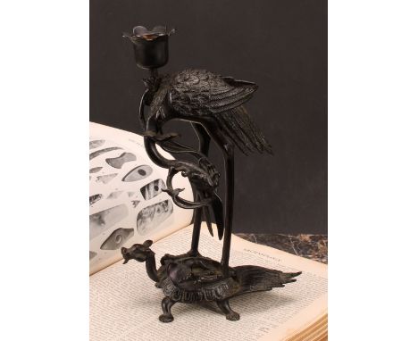 A Chinese dark patinated bronze candlestick, cast as a crane standing upon a turtle, 24cm high, six character mark, early 20t