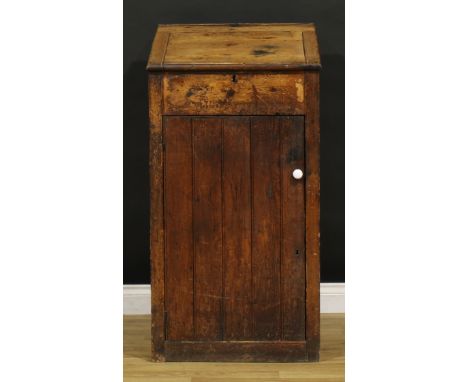 A late Victorian primitive vernacular pine porter’s or shopkeeper’s reception pedestal, hinged top above a door enclosing a s