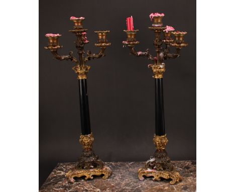 A pair of 19th century gilt and dark patinated bronze, and black marble four-light table candelabra, campana sconces, triform