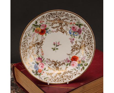 A Swansea or Nantgarw circular dished plate, painted with colourful summer flowers, within a broad elaborate gilt border of s