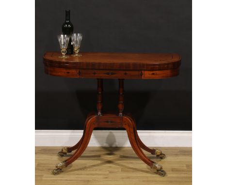 A Regency mahogany D-shaped card table, hinged top inlaid with naval anchors and enclosing a baize lined playing surface, tur