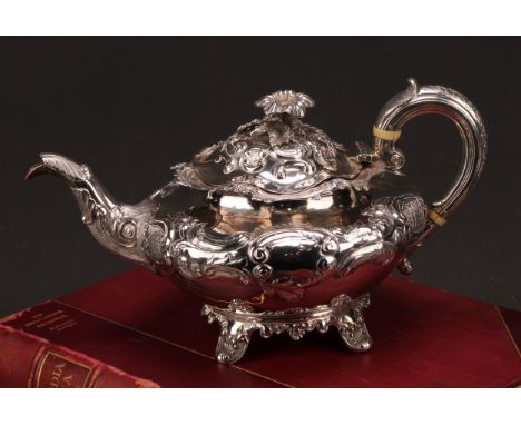 A William IV Rococo Revival silver compressed ovoid teapot, chased with flowers and scrolls, hinged domed cover with flower f