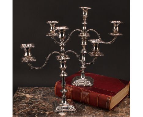 A pair of Edward VII silver table candlesticks, campana sconces, detachable nozzles, fluted square base, 23.5cm high, Fordham