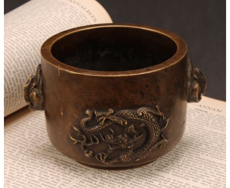 A Chinese bronze censer, cast in relief with dragons chasing a flaming pearl, masks to sides, 13cm wide, seal mark 