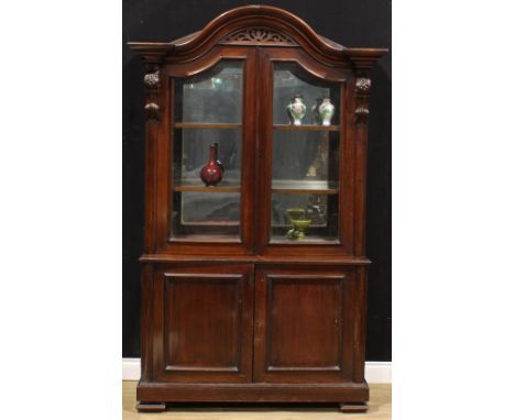 A Victorian mahogany shop display case or library bookcase, arched cornice above a pair of glazed doors enclosing a mirror pl