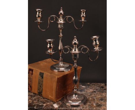A pair of George III Old Sheffield Plate two-light table candelabra, campana sconces, slender baluster pillars, domed bases c