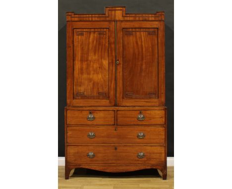A George IV mahogany linen press, podium-shaped cornice above a pair of panel doors enclosing a shelf and four sliding trays,