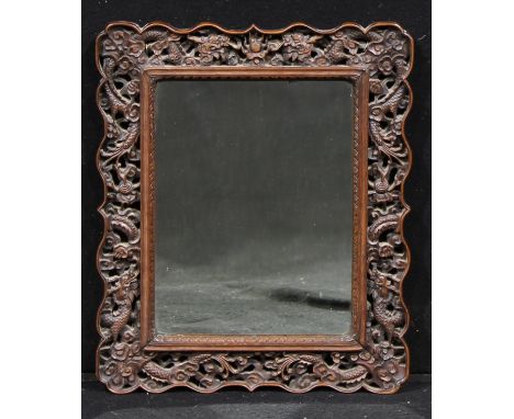 A Chinese hardwood looking glass, rectangular mirror plate, the shaped frame pierced and carved with dragons amongst scrollin