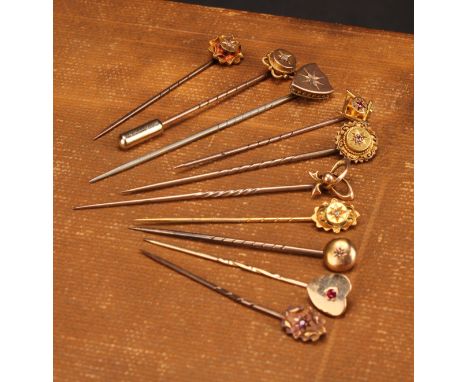 Stick Pins - a 15ct gold and diamond flowerhead stick pin, set with a single diamond chip; another similar; another similar, 