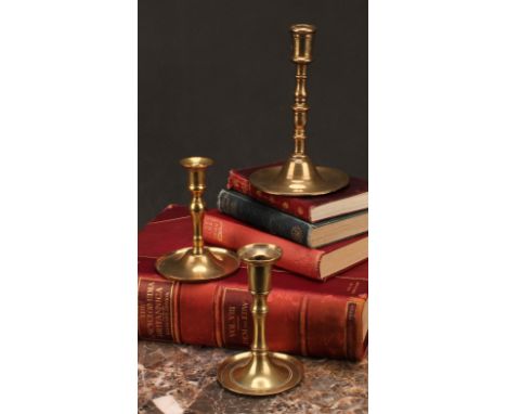 A 17th century brass candlestick, knopped pillar, domed slightly dished base, 18cm high, c.1680; others, probably German (3) 