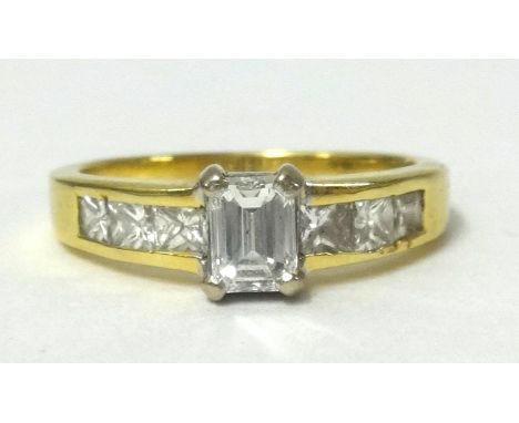 18ct diamond set ring with centre emerald cut stone and princess cut diamonds to the shoulders, finger size N