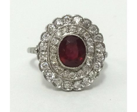 A ruby and diamond cluster ring, set in probably platinum overall size 15mm x 16mm, finger size M.