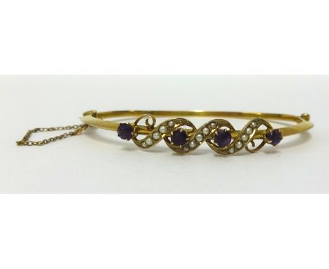 A yellow metal bangle set with amethyst and seed pearl approx 5.4gms.