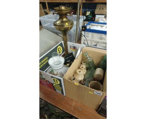 Modern uplighter, oil lamp and a box of bottles