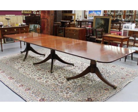 Very large Regency-style mahogany triple pillar dining table, the expansive rounded rectangular top raised on ring-turned col