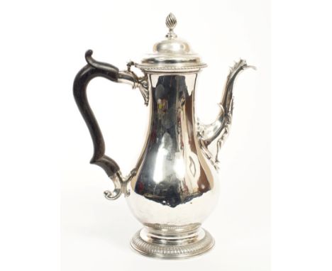 George III silver coffee pot of baluster form, with ornate spout, ebony scroll handle and hinged domed cover with gadrooned b