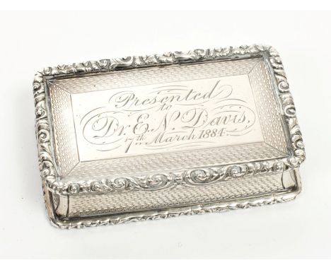 Victorian silver snuff box of rectangular form, with engine-turned decoration, cast scroll borders and hinged cover with engr