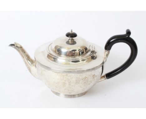 1930s silver teapot of cauldron form, with reeded borders, ebonised loop handle and hinged domed cover with ebonised finial, 