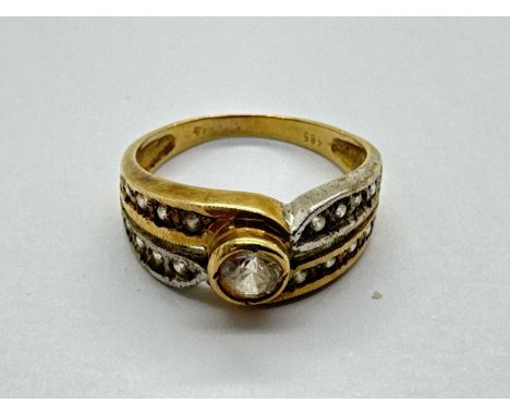 A Two-Tone Stone Set Dress Ring, of bifurcated crossover design, the collet set centre stone between stone set shoulders and 