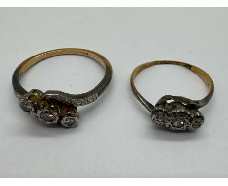 A Three Stone Diamond Crossover Ring, the brilliant cut centre stone between old cut diamond side stones, collet set to starb