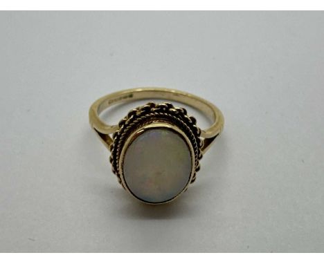 A 9ct Gold Single Stone Dress Ring, the oval collet set stone within twist style surround, to bifurcated slim band (finger si