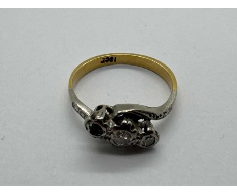 An Antique Style Three Stone Diamond Crossver Ring, (one stone missing), the brilliant cut diamonds rubover set to two-tone c