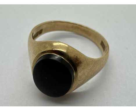 A 9ct Gold Stone Set Signet Ring, the centre panel of oval form, between wide tapering shoulders (finger size L1/2) (2.9grams