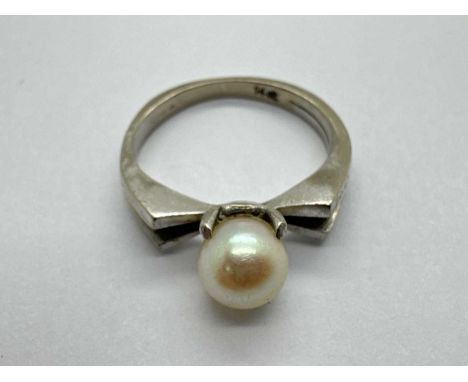 A Freshwater Pearl Bead Set Ring, four claw set between bifurcated angular shoulders and tapering band stamped "14ct" (white)