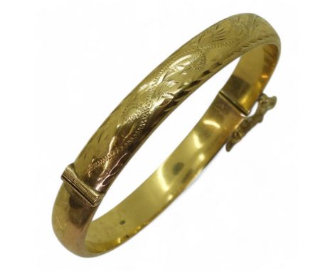 A 9ct gold engraved bangle, inner dimensions 6cm x 5.5cm, weight 10.4gms Condition Report:Available upon request
