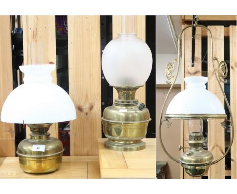 A lot comprising a Victorian brass hanging oil lantern with opaque glass shade and another two brass free standing oil lamps 